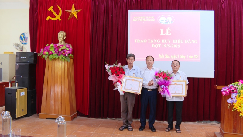 Đồng chí Giàng A Dơ UVBTV Huyện uỷ,  Bí thư Đảng uỷ Thị trấn Tuần Giáo trao huy hiệu 40 năm tuổi đảng cho 02 đảng viên